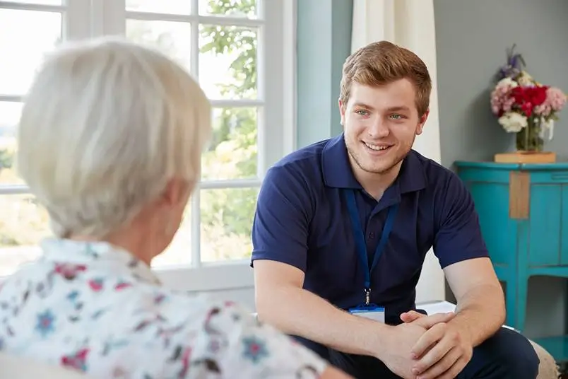 Seniorin und Pflegekraft im Gespräch bei einer gemeinsamen Aktivität